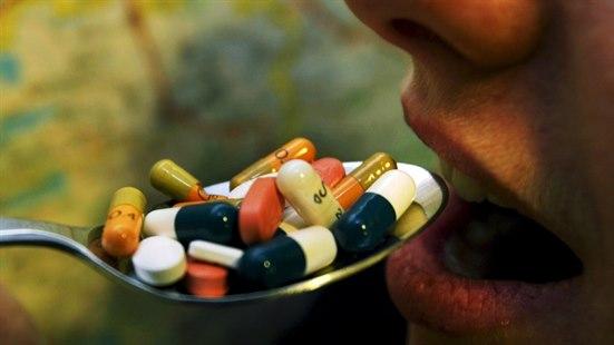Illustrasjonsfoto av en person som skal til å spiser en skje med tabletter.