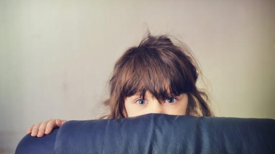 Barn skjuler seg bak seng