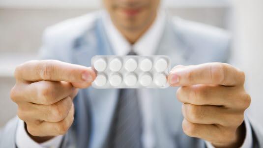 Tabletter Illustrasjonsfoto av en mann som holder opp et brett med tabletter.