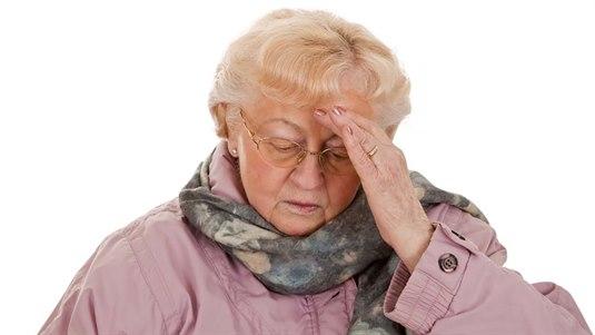 Hodepine En eldre og pent kledd dame holder seg på hode
