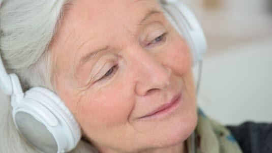 Eldre dame lytter til musikk