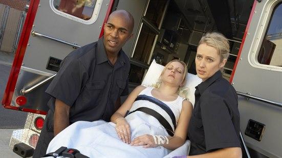 ambulanse, akutt.jpg Illustrasjonsfoto av to ambulansearbeidere som løfter en pasient i en bære båre ut av ambulansen