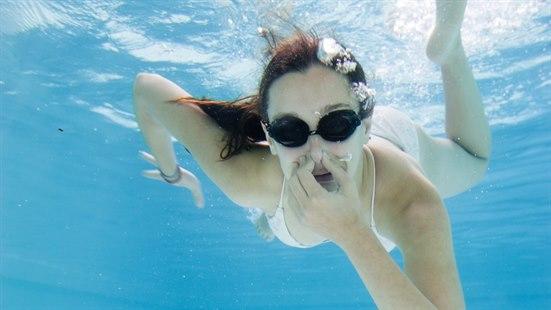 Dykking Illustrasjonsfoto av ei dame som dykker. Hun bruker svømmebriller og holder seg for nesen.