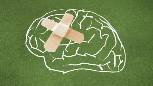 Hjerneskade En hjerne tegnet med hvit kritt på et grønt papir, som har to plaster i kryss på venstre side