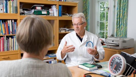 Legekonsultasjon Illustrasjonsfoto fra en legekonsultasjon. En mannlig eldre lege ser ut til å forklare noe for en kvinnelig pasient. Pasienten sitter med ryggen til fotografen.
