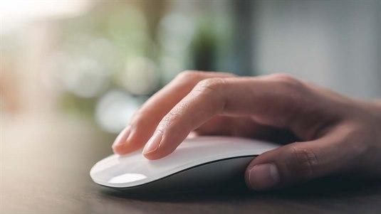 PC-mus En hånd som hviler på en Apple datamus. Fingerspissene er lett plassert på musens overflate og håndflaten er flat og avslappet.