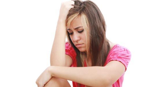 Svimmel Illustrasjonsfoto av ung jente som sitter og som støtter hodet med armen.